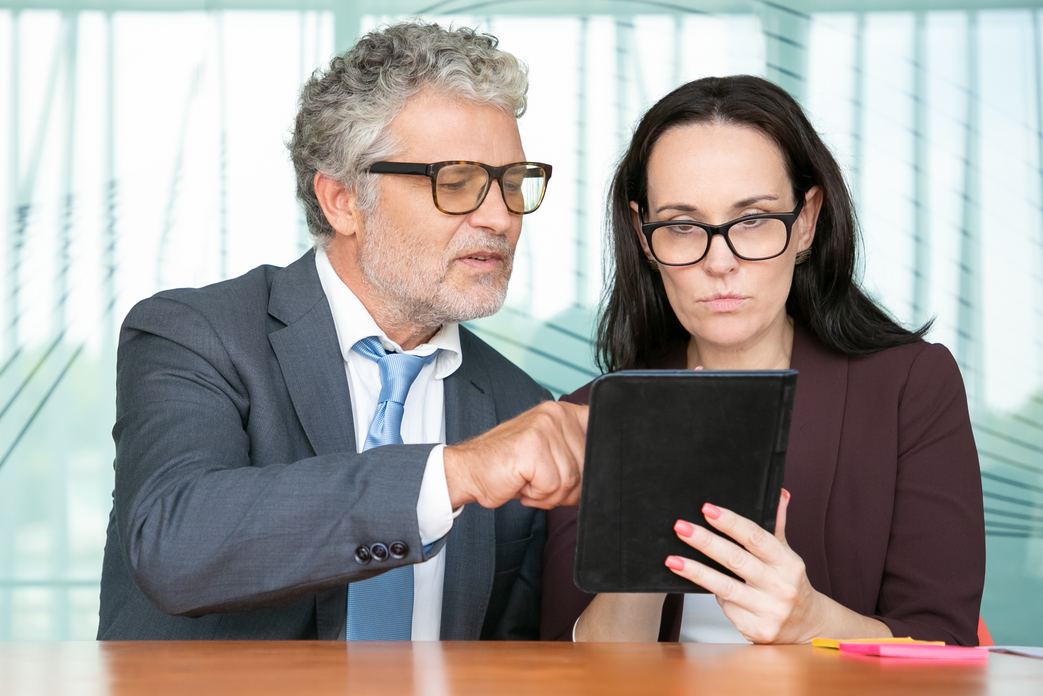 Focused Colleagues Watching Presentation Tablet Together Looking Screen While Sitting Table Office