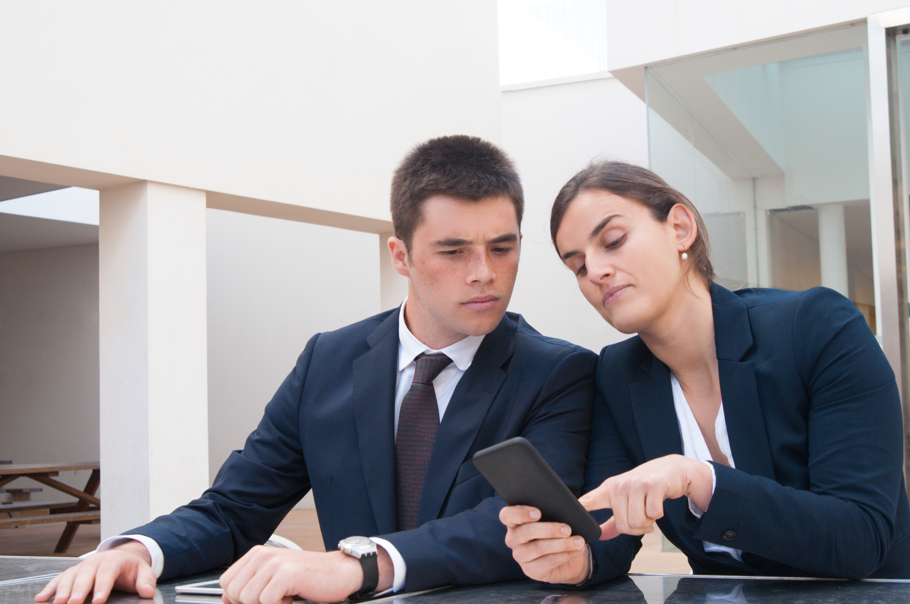 Business Woman Showing Information Phone Screen Coworker