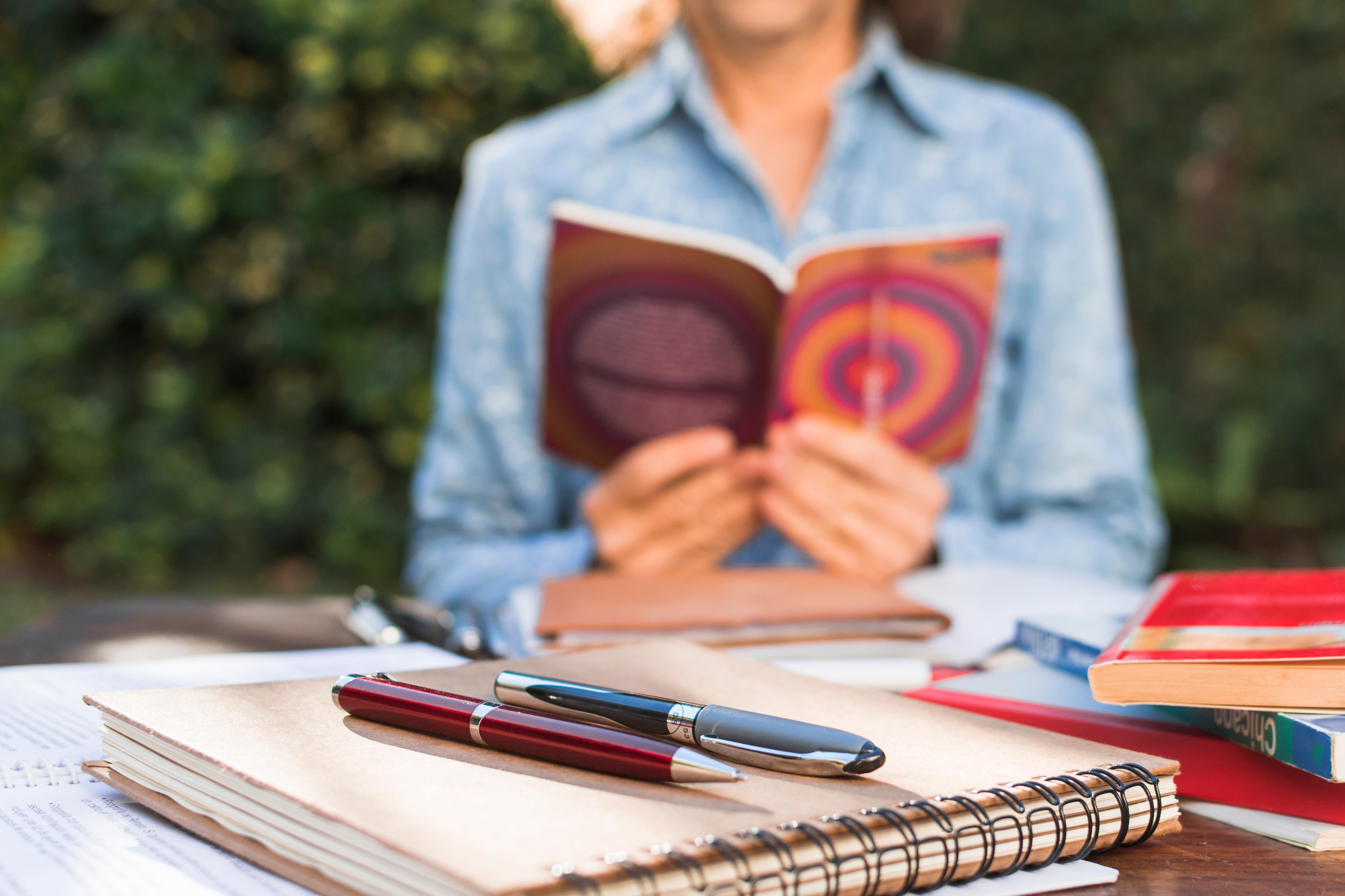 Notebook Pens Near Reading Woman