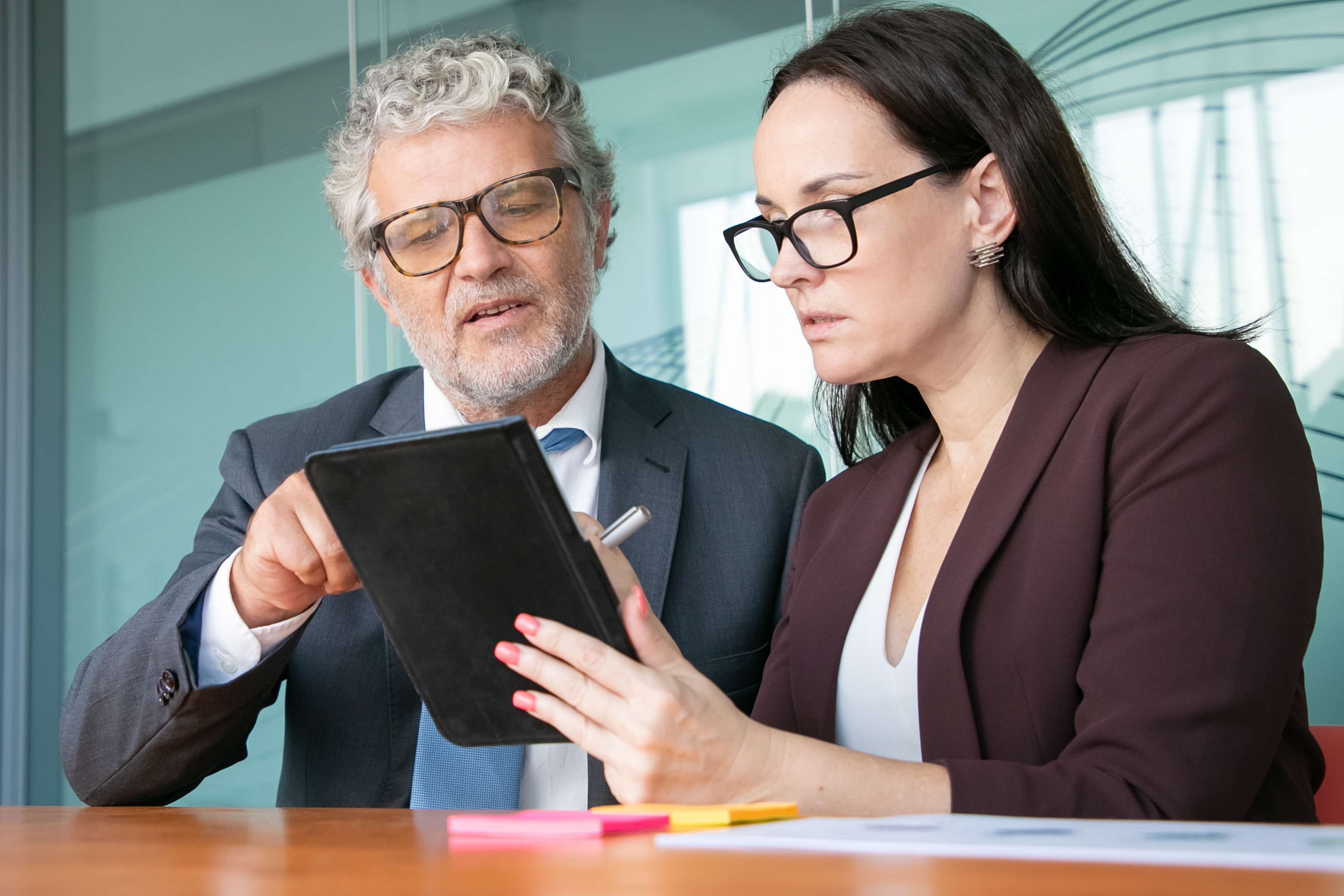 Female Assistant Showing Report Tablet Male Boss