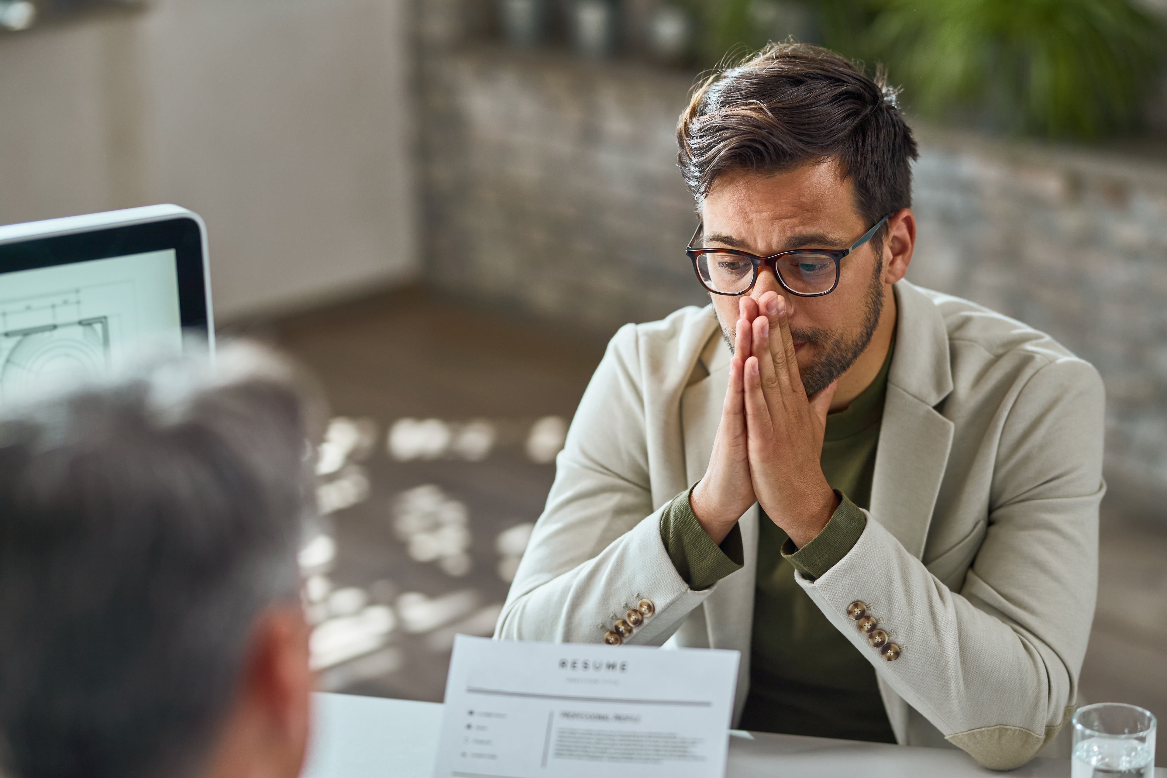 Distraught Young Man Feeling Uncertain While Having Job Interview Office