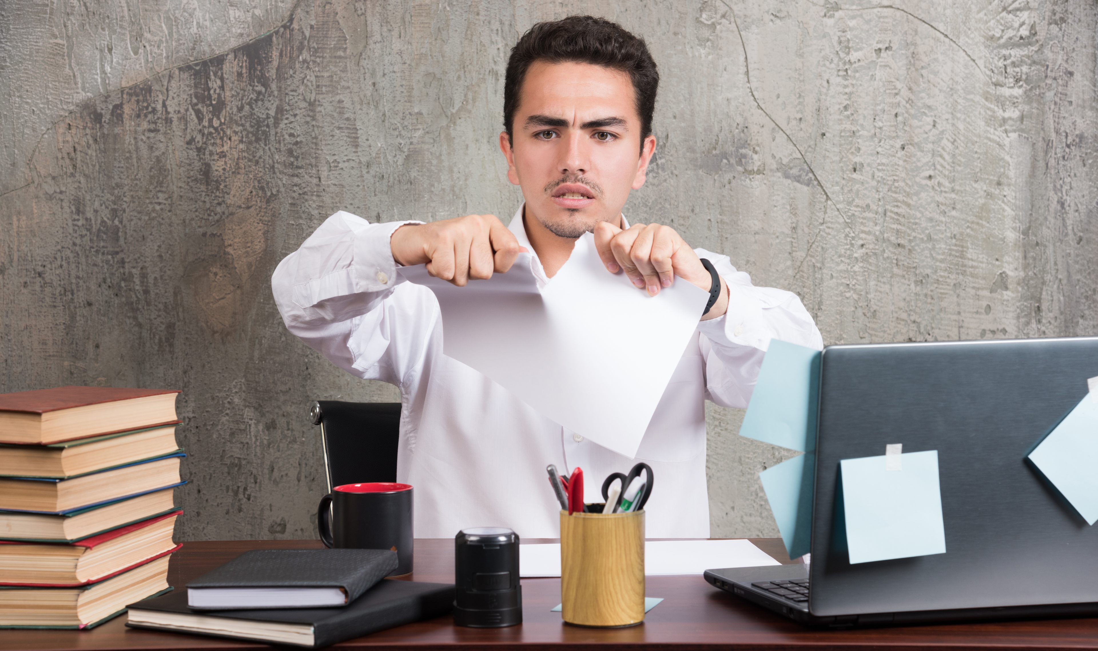 Crazy Businessman Splitting Paper Office Desk